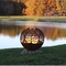 灰皿が付いている鋼鉄地球球の火ピットを風化させる秋の日没の葉