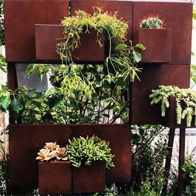 前に風化させたコルテンの鋼鉄壁の芸術の無作法な壁掛けの植木鉢